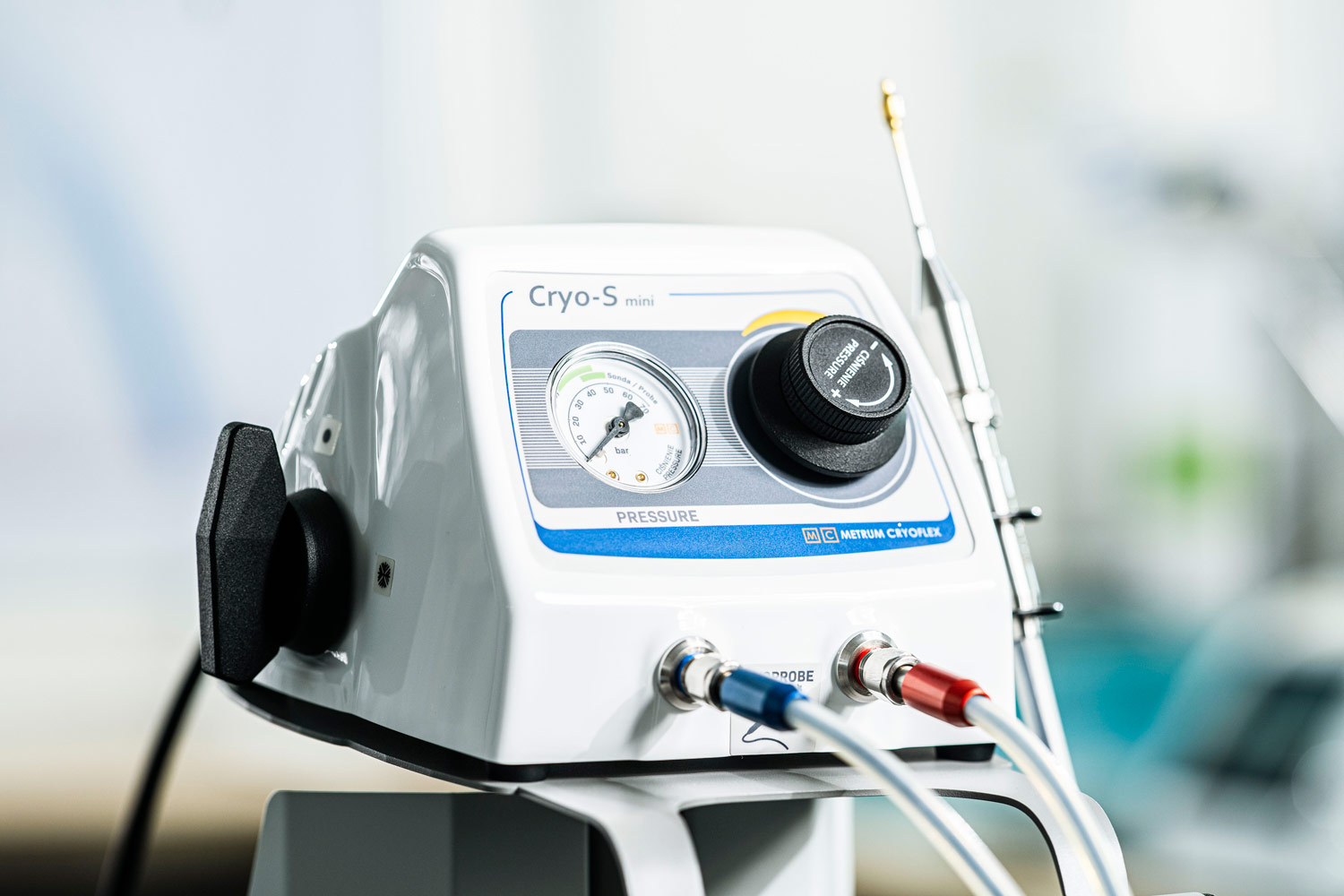 A CRYO-S Mini készülék közelről: nyomásmérő óra, nyomásszabályzó gomb, valamint a kék és piros jelölésű kriofej-csatlakozók a csatlakoztatott tömlőkkel